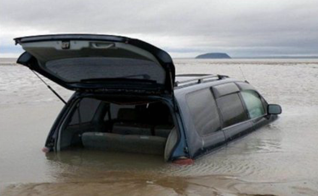 汽车深陷沙滩遭遇浪潮，车主淡定坐在车上玩手机 第1页