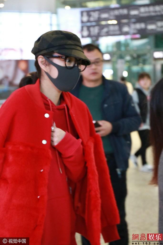 安以轩一身红衣现身机场 口罩遮面玩快闪