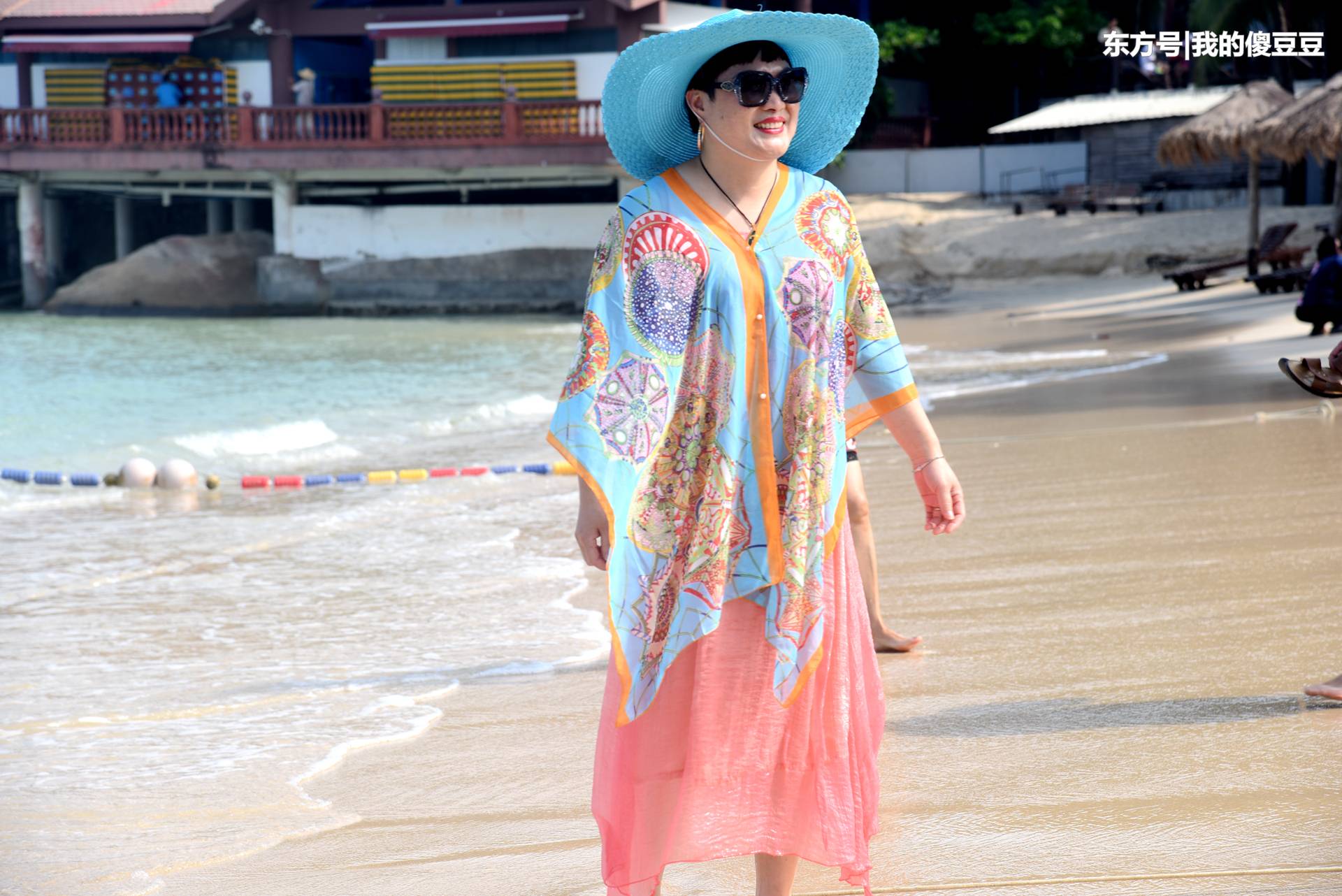 游客在海滩拍照爱用丝巾 阿姨为摆姿势全身湿透 第1页